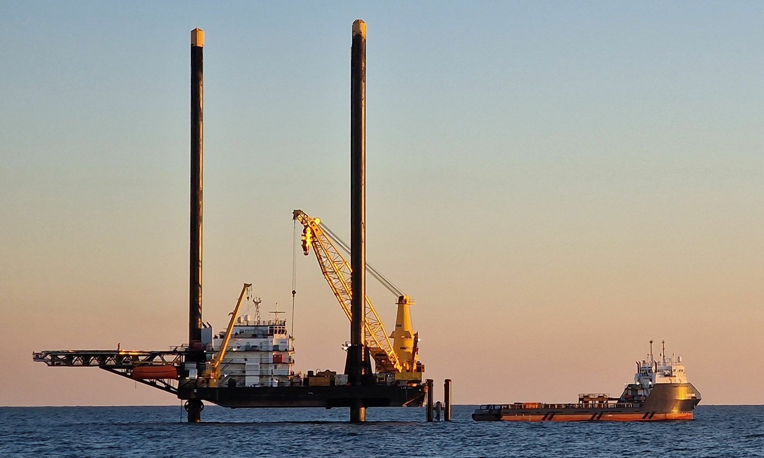 Liftboat and supply vessel setting up for an offshore wind farm